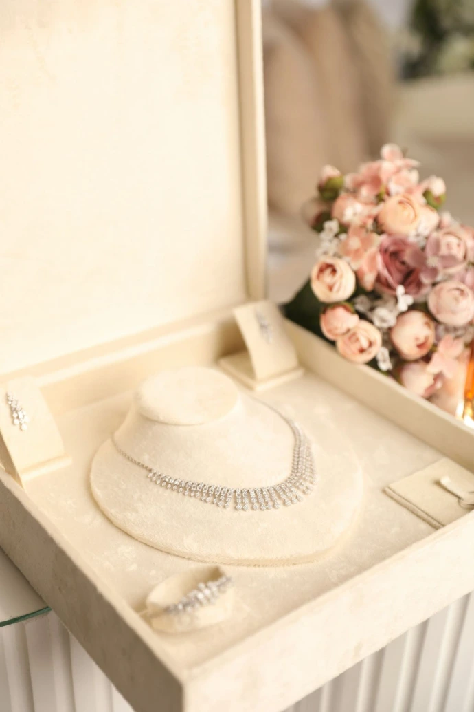 a white hat and necklace in a white box